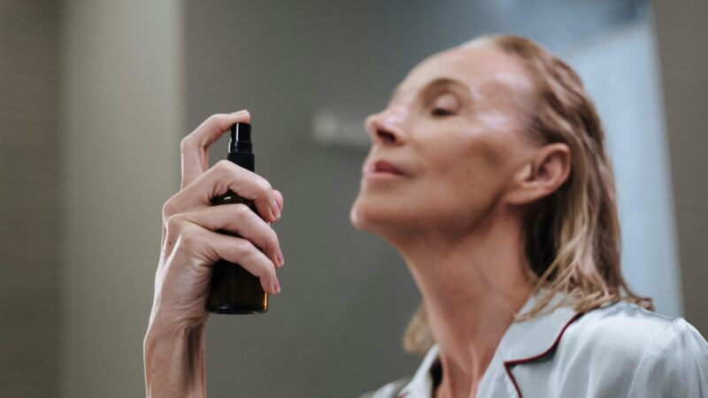 Woman Applying Serum in Mirror